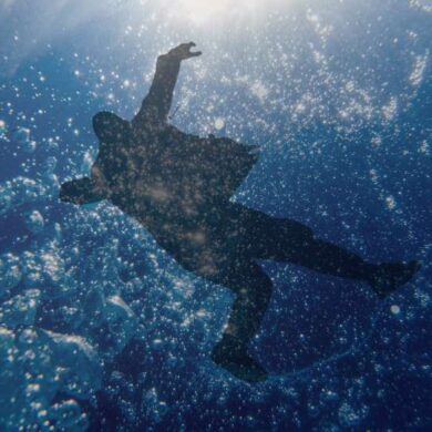 Osoba całkowicie zanurzona pod wodą - symbol chrztu przez pełne zanurzenie