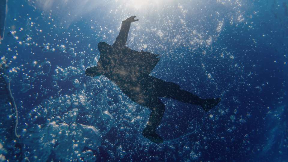 Osoba całkowicie zanurzona pod wodą - symbol chrztu przez pełne zanurzenie